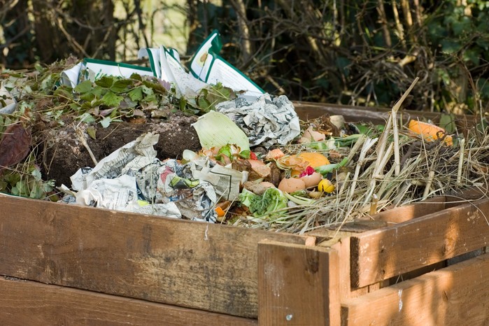 An open-topped compost heap with sides made of wooden slats